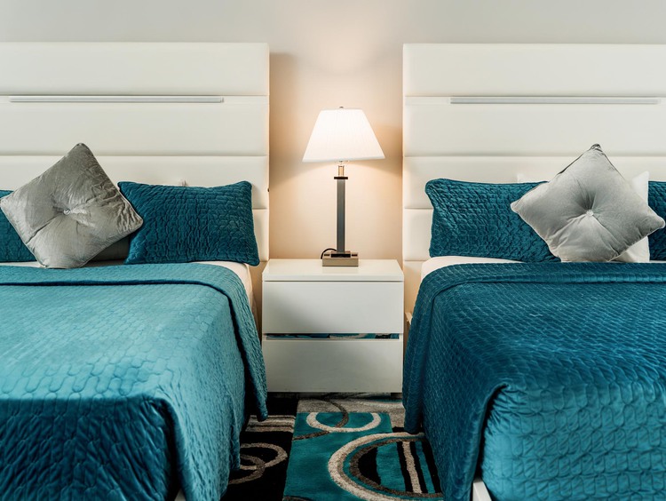 two beds with blue comforters