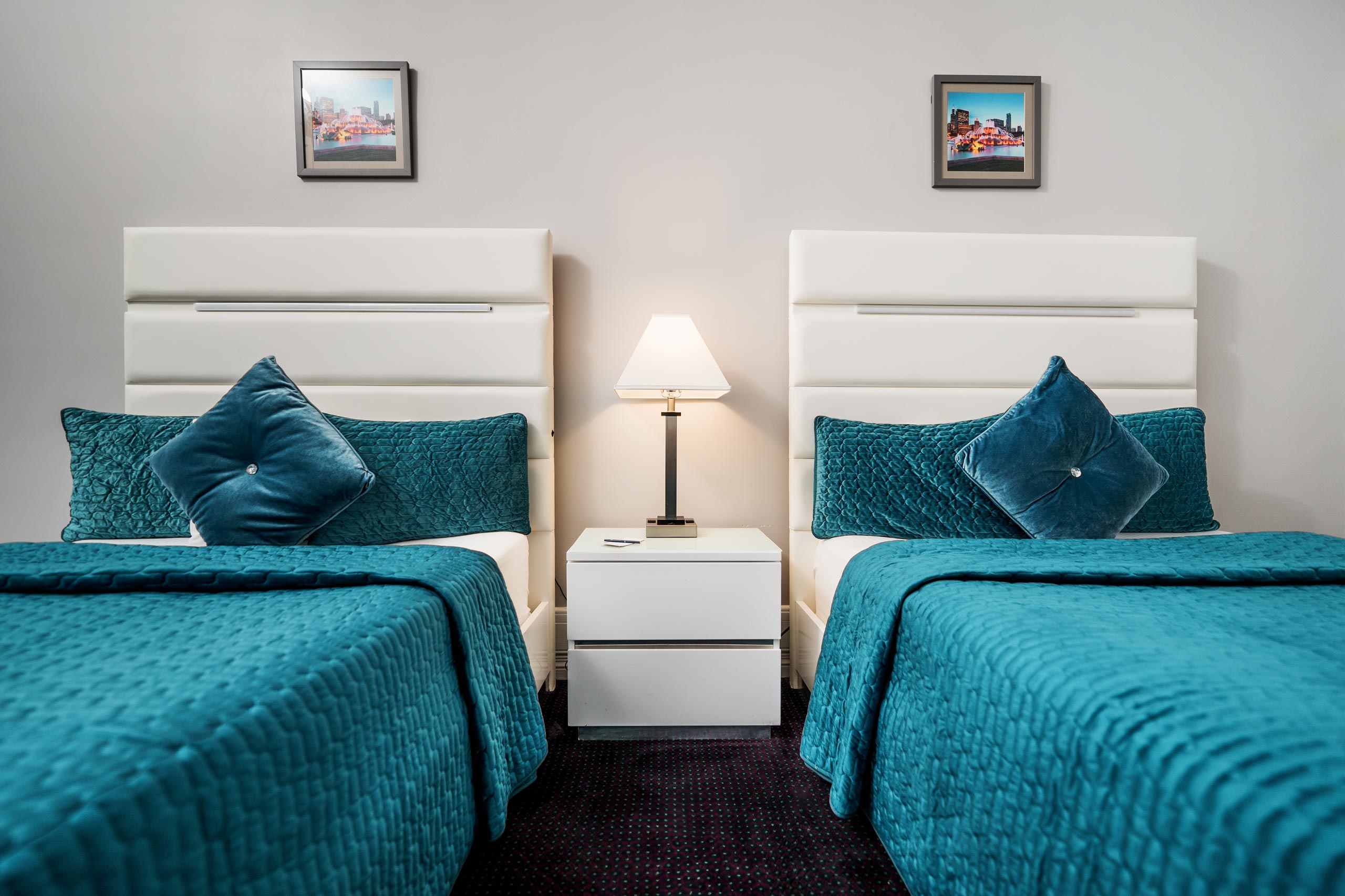 Two beds with blue sheets and pillow